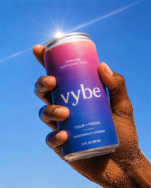 Product shot of a gradient soda can held up against a clear sky